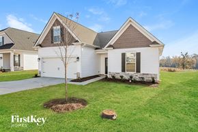 Greenville house for rent - A white house with a brown roof and a tree in the front yard.