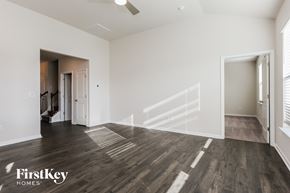 Greenville house for rent - A spacious room with wooden flooring and a staircase leading to another room.