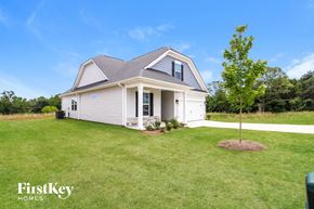 Greenville house for rent - a small white house with a yard and a tree