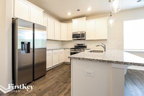 Greenville house for rent - a kitchen with white cabinets and a counter top and stainless steel refrigerator