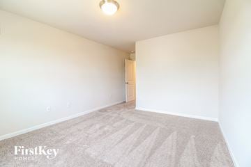Greenville house for rent - a spacious living room with carpet and white walls