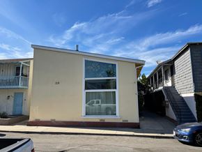 Long Beach apartment for rent - A beige house with a blue car parked in front.