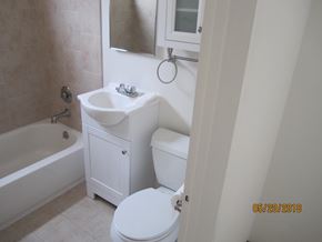 Long Beach apartment for rent - A white bathroom with a toilet, sink, and bathtub.
