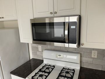 Long Beach apartment for rent - A kitchen with a stove and a microwave above it.