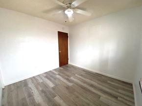 Atwater house for rent - an empty room with wood flooring and a ceiling fan