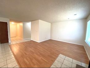 Atwater house for rent - an empty living room with wood flooring and white walls