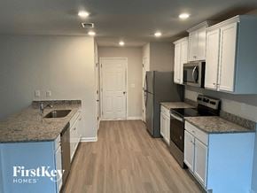 Charlotte house for rent - a kitchen with white cabinets and stainless steel appliances