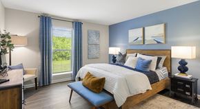 Chattanooga townhouse for rent - A bedroom with a large bed and a window with blue curtains.