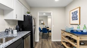 Chattanooga townhouse for rent - A kitchen with black appliances and a dining table with chairs in the background.