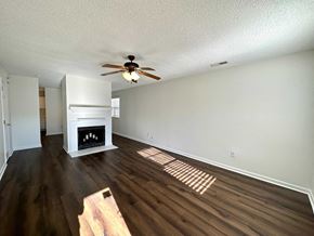 Greer house for rent - a living room with a fireplace and a ceiling fan