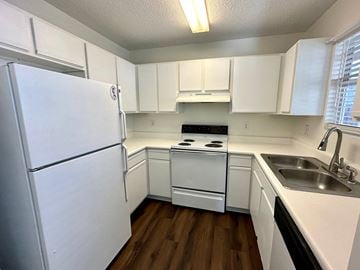 Greer house for rent - a kitchen with white cabinets and a sink and a refrigerator