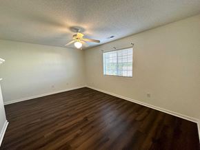 Greer house for rent - an empty living room with a ceiling fan and a window