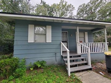 Jacksonville house for rent - the front of a blue house with a porch and stairs