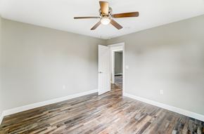 Elida apartment for rent - an empty living room with wood floors and a ceiling fan