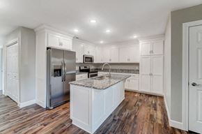 Elida apartment for rent - a kitchen with white cabinets and a marble counter top