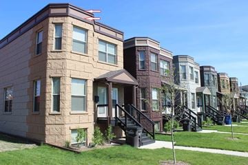 Des Moines triplex for rent - A row of townhouses with a clear blue sky above them.