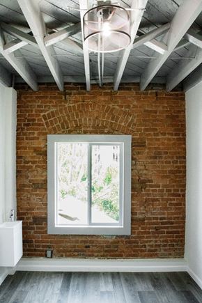Los Angeles apartment for rent - A room with a brick wall and a window showing trees outside.