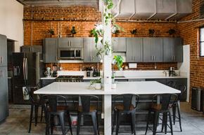 Los Angeles apartment for rent - A kitchen with a table and chairs in front of a brick wall.