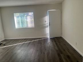 Los Angeles apartment for rent - A room with a wooden floor and a white door.