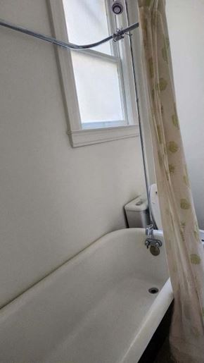 San Francisco apartment for rent - a bathroom with a tub and a window and a shower curtain