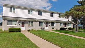 Pontiac apartment for rent - a white building with a sidewalk in front of it