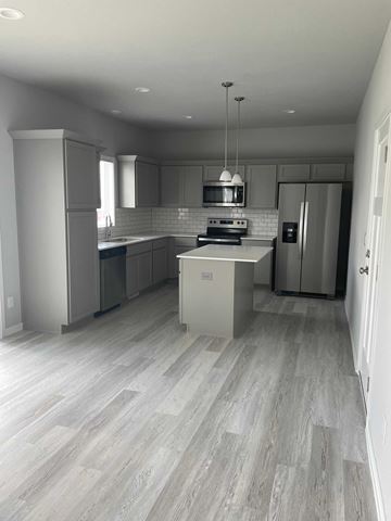 Urbandale house for rent - a brand new kitchen with white cabinets and stainless steel appliances