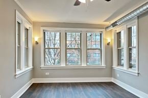 Oak Park apartment for rent - A room with a large window and a ceiling fan.