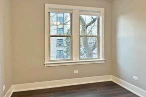 Oak Park apartment for rent - A room with a large window showing a view of a building and a tree outside.