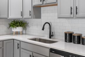 Jeffersonville apartment for rent - a kitchen with white cabinets and a sink and a black faucet
