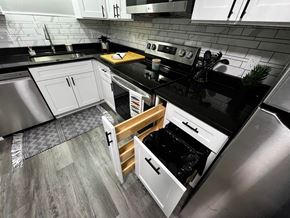Trenton apartment for rent - A modern kitchen with black countertops and white cabinets.