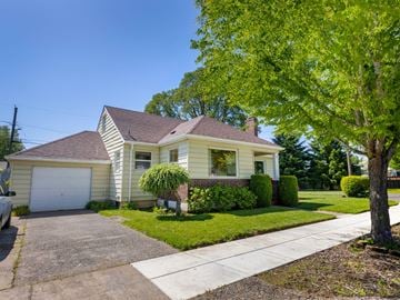 Portland house for rent - A house with a garage and a tree in front.