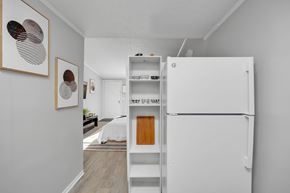 Jacksonville apartment for rent - A white refrigerator is in a room with a bed in the background.