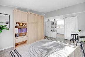 Jacksonville apartment for rent - A modern kitchen with wooden cabinets and a striped rug on the floor.