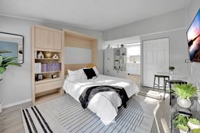 Jacksonville apartment for rent - A bedroom with a large bed and a TV on the wall.