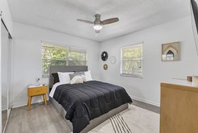 Boca Raton apartment for rent - A bedroom with a bed, nightstand, and a ceiling fan.