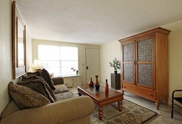 Titusville apartment for rent - A living room with a brown couch and a wooden cabinet.