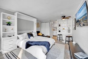 Jacksonville apartment for rent - A bedroom with a bed, a ceiling fan, and a painting on the wall.