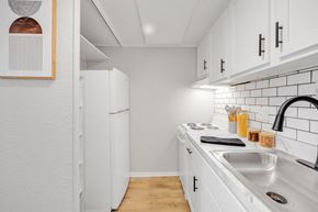 Jacksonville apartment for rent - A kitchen with white cabinets and a white fridge.