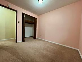 Longview house for rent - an empty living room with pink walls and a door to a closet