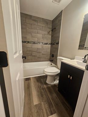 St. Louis house for rent - A bathroom with a toilet, sink, and a bathtub.