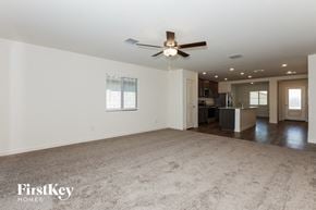 Florence house for rent - an empty living room with a ceiling fan and a kitchen