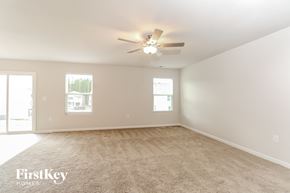 Charlotte house for rent - A spacious room with a carpeted floor and a ceiling fan.