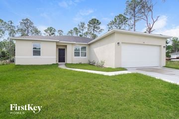 Palm Bay house for rent - a beige house with a lawn in front of it