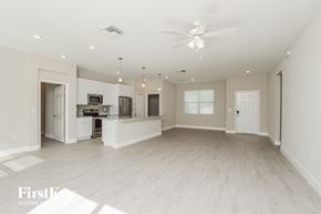 Palm Bay house for rent - an empty living room with a kitchen and a ceiling fan