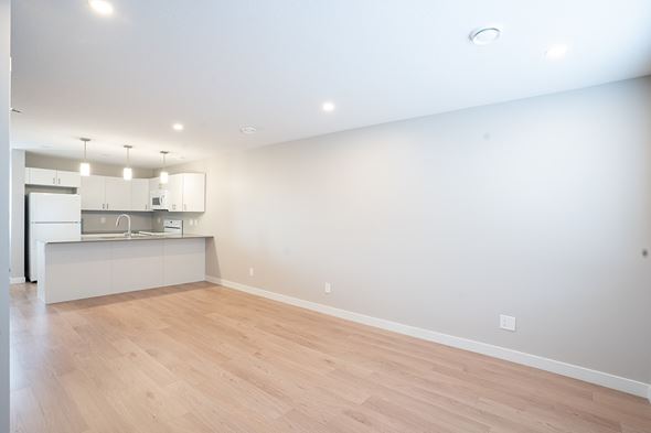 Regina apartment for rent - A kitchen with white cabinets and a wooden floor.