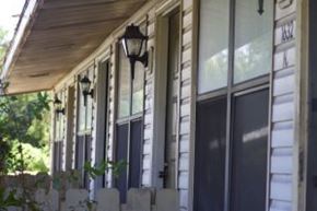 Brandon apartment for rent - A white house with a porch and a black lamp post.