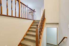 Eagan house for rent - a stairway in a house with a wooden railing and carpeted stairs