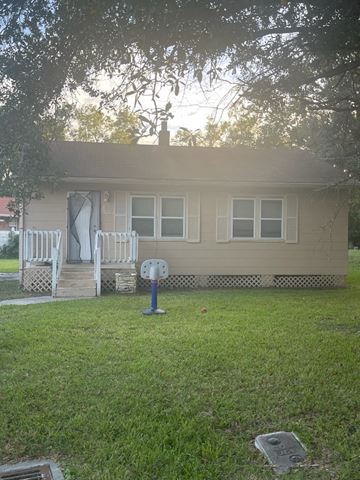 Jacksonville house for rent - a house with two white rocking chairs in the yard
