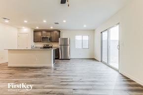 Florence house for rent - the living room and kitchen of an apartment with wood flooring and stainless steel appliances