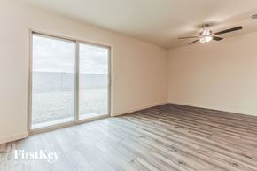 Florence house for rent - a living room with wood floors and a large window and a ceiling fan
